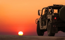 Солдаты в Hummer H1 смотрят на красивый закат солнца